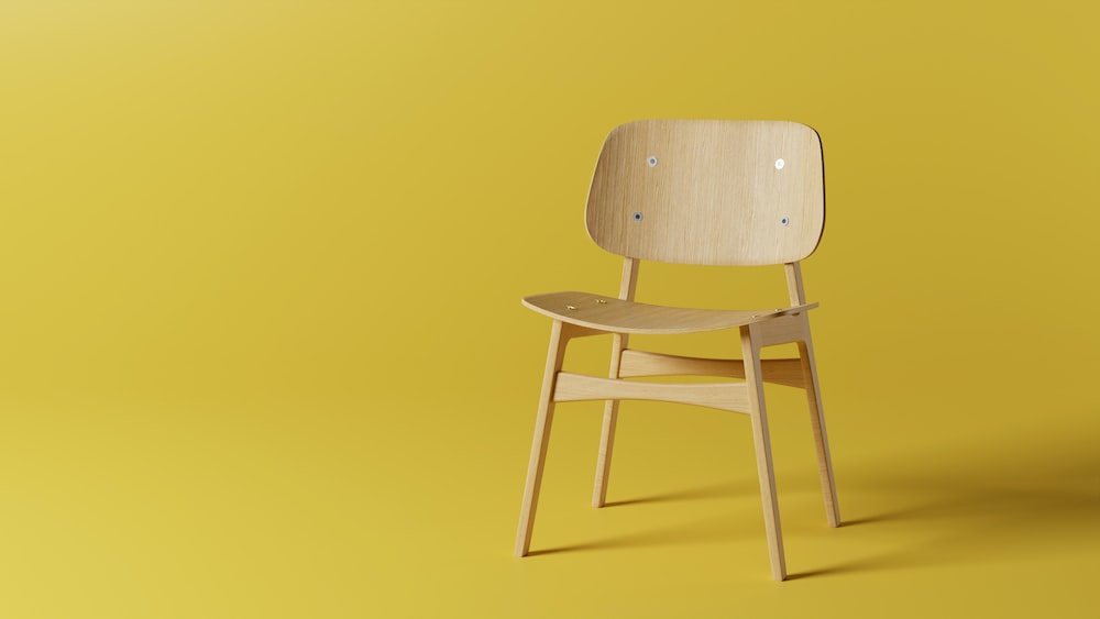 a wooden chair on a yellow background