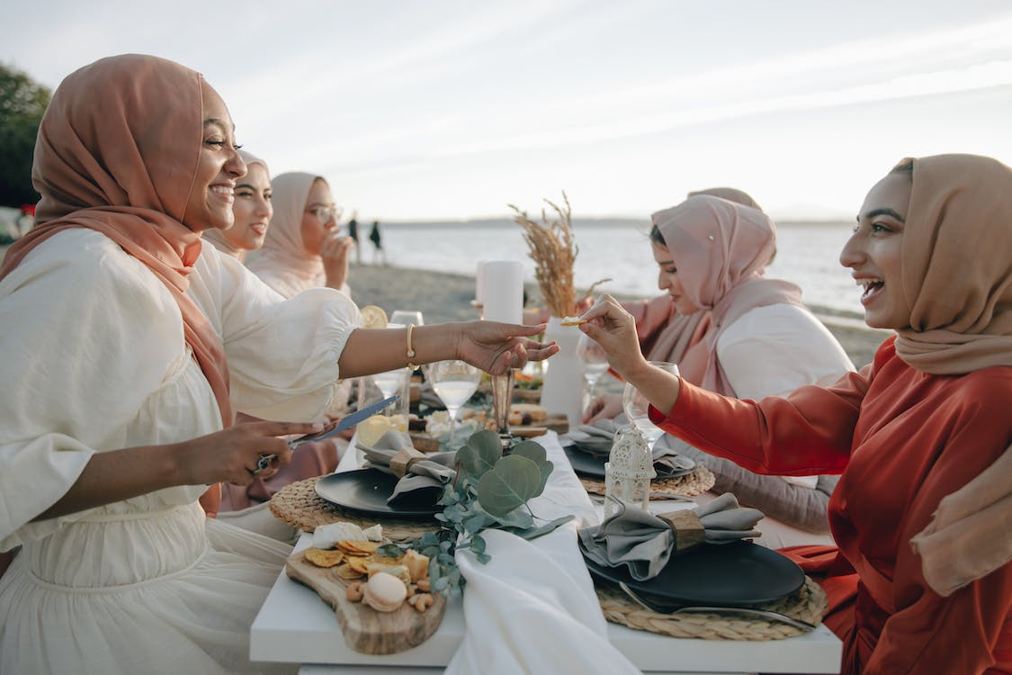 Free Women in Hijab Having Picnic on the Beach Stock Photo