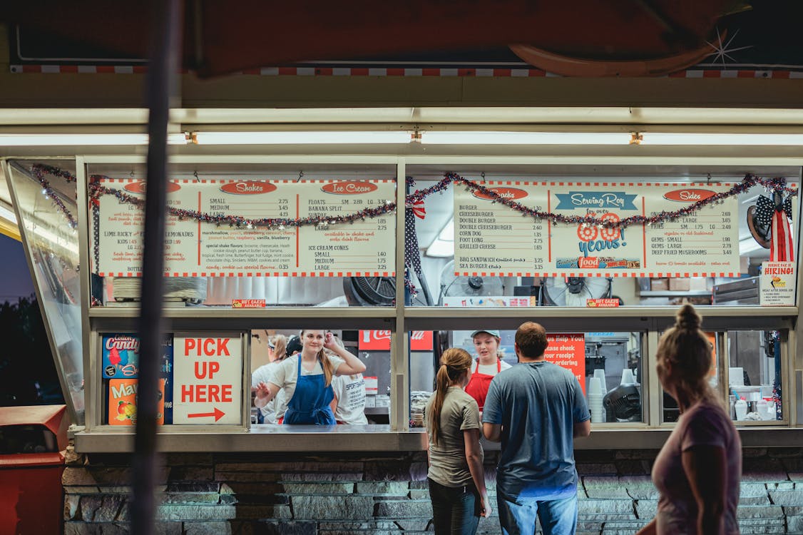 Free Man and Woman Ordering Food at a Fast Food Restaurant Stock Photo